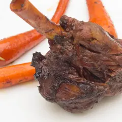Roussette au vin blanc, une recette de cuisine actuelle, servie avec des carottes glacées sur une assiette blanche.