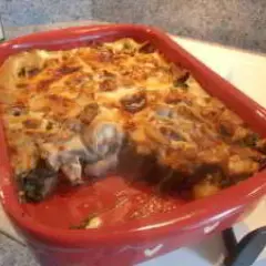 Un gratin des Chartreux tout juste sorti du four, fumant et doré, dans un plat rouge.