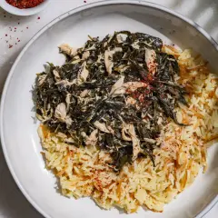 Un plat de mloukhia libanais avec du riz aux vermicelles, garni de poulet effiloché et d'épices rouges.