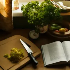 Sur une planche à découper, du persil jauni est prêt à être utilisé. Une recette ouverte et des légumes attendent. Peut-on manger du persil jauni ?