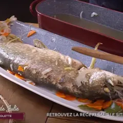 Un brochet au court-bouillon, prêt à être servi avec une mayonnaise maison. Il est garni de carottes et d'oignons.