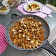 Plat de fruits de mer et porc mijoté dans une sauce savoureuse, prêt à être dégusté. Une recette cataplana porc et fruits de mer qui met l'eau à la bouche.