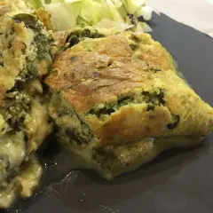 Une savoureuse omelette à l'oseille à l'ancienne, dorée et moelleuse, servie avec une salade verte.