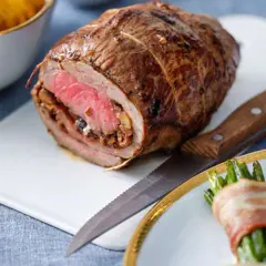 Un rôti de bœuf farci, prêt à être découpé, évoque une délicieuse recette rosbif alsacien. Accompagné de haricots verts enroulés de lard.