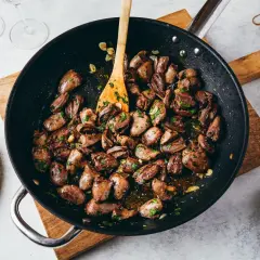 Poêlée de cœurs de canard aux herbes et à l'ail, prêts à être dégustés. Un plat savoureux et simple.