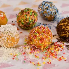 Boules de gofio recette : décorées de vermicelles colorés, de copeaux de noix de coco, de vermicelles bleus et de vermicelles chocolat.