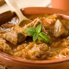 Un plat de goulash polonais réconfortant, avec des morceaux de viande tendre et du chou, garni de menthe fraîche. Parfait pour une recette maison.