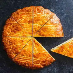 Un délicieux gâteau arménien, doré et coupé en parts, avec une tranche déjà servie.