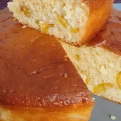Un gâteau vosgien aux mirabelles, doré et moelleux, avec des morceaux de fruits jaunes visibles à l'intérieur.