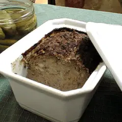 Terrine de foie de volaille à l'ancienne, prête à être dégustée avec des cornichons croquants.