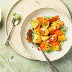 Délicieuse recette pomme de terre carotte en sauce verte crémeuse, garnie d'herbes fraîches et de graines de sésame noir.