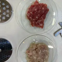 Préparation de viande hachée pour savoir combien de sel et poivre par kg de viande. Disques de hachoir et lames à proximité.