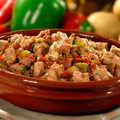 Un plat d'axoa de veau, mijoté avec des poivrons et des oignons, servi dans un bol en terre cuite. Parfait pour savoir si on peut préparer un axoa de veau la veille.