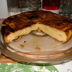 Une délicieuse farinette aux pommes, dorée et moelleuse, servie sur un plat en verre. Un vrai régal !