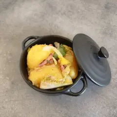 Un plat de pommes de terre et lardons, rappelant la recette ardennaise de nos grands-mères, servi dans une cocotte noire.