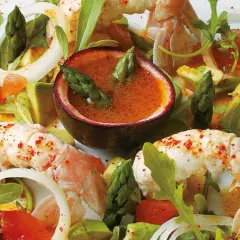 Salade de langouste aux agrumes et avocat, avec asperges et fruits de la passion. Un plat frais et coloré.