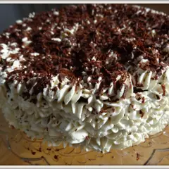 Gâteau noir en chemise de crème fouettée et copeaux de chocolat.