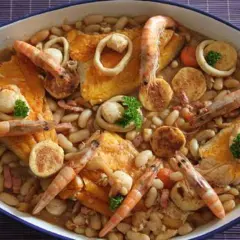 Un cassoulet de la mer facile, un plat généreux avec des crevettes, des calamars et des poissons sur un lit de haricots blancs.