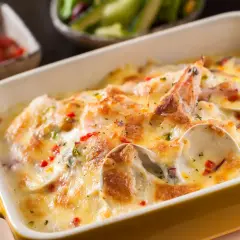 Gratin de coquilles Saint-Jacques, moules, crevettes et champignons, nappé d'une sauce crémeuse et gratiné au fromage. Un délice !