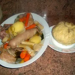 Un plat généreux de la mique origine, avec saucisse, légumes et viande, accompagné d'une mique ronde.
