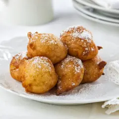 Délicieuses beignets saupoudrés de sucre glace, parfaits pour une recette crotte d'âne maison.