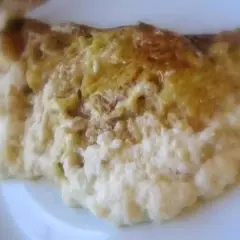 Une omelette normande dorée, moelleuse et savoureuse, servie sur une assiette blanche.