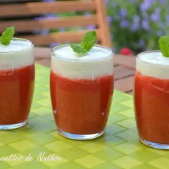 Trois verres de soupe fraise menthe, garnie d'une feuille de menthe, sur une table verte.