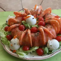 Couronne aux deux saumons, décorée de crevettes, tomates cerises, œufs durs en forme de poulets et de lapins, sur un lit de salade.