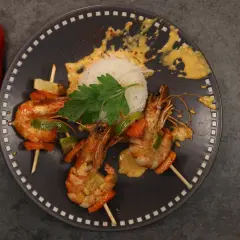 Brochettes de crevettes au chorizo et crème, servies avec du riz blanc et des poivrons.
