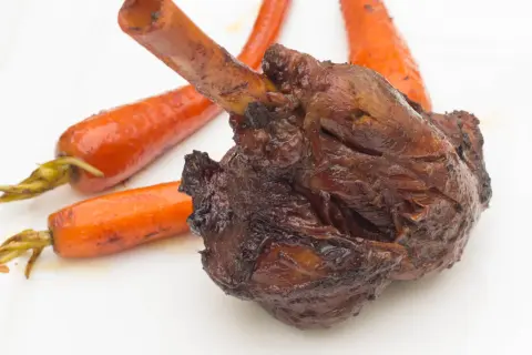 Roussette au vin blanc, une recette de cuisine actuelle, servie avec des carottes glacées sur une assiette blanche.