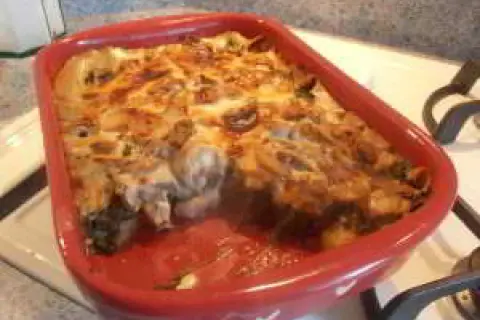 Un gratin des Chartreux tout juste sorti du four, fumant et doré, dans un plat rouge.