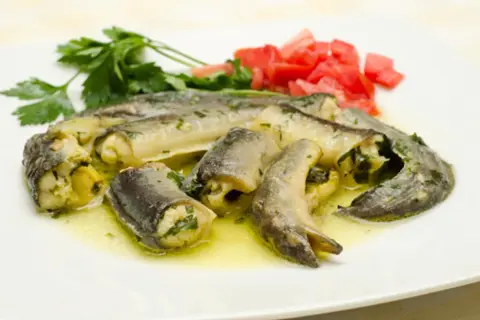 Poisson farci, servi avec des tomates et du persil. Une délicieuse recette de catigot, prête à être dégustée.