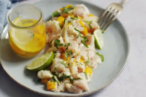 Délicieux ceviche de lieu noir frais, garni de mangue, coriandre et citron vert, servi avec une vinaigrette citronnée.