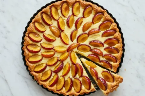 Tarte aux pommes et mirabelles, garnie d'une crème onctueuse et de fruits rouges et jaunes. Un délice !
