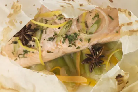 Un pavé de saumon cuit en papillote avec des légumes croquants, des zestes de citron et des étoiles de badiane. Un délice pour un barbecue sain.