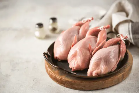 Trois cailles crues, prêtes pour une savoureuse sauce chasseur.