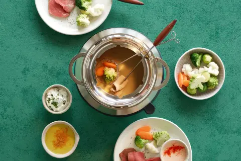 Fondue au bouillon cube avec viande, brocolis, chou-fleur et carottes. Des sauces accompagnent ce plat convivial.