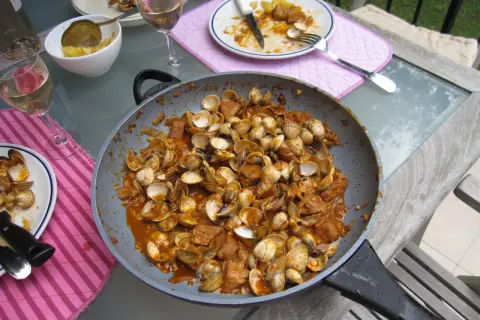 Plat de fruits de mer et porc mijoté dans une sauce savoureuse, prêt à être dégusté. Une recette cataplana porc et fruits de mer qui met l'eau à la bouche.