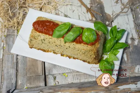 Un délicieux flan de courgettes, garni de sauce tomate et de feuilles de basilic frais, prêt à être dégusté.