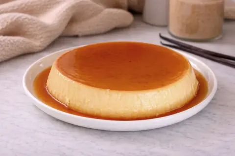 Crème aux œufs onctueuse, nappée de caramel ambré, prête à être dégustée. Une recette simple et gourmande.