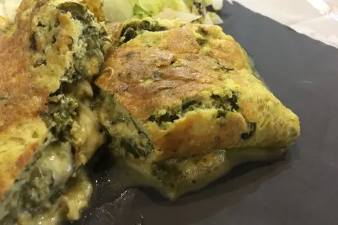 Une savoureuse omelette à l'oseille à l'ancienne, dorée et moelleuse, servie avec une salade verte.