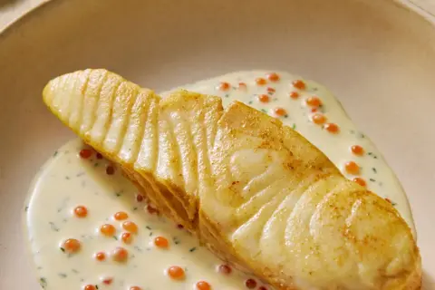 Un flétan poêlé, nappé d'une sauce crémeuse aux œufs de poisson, une flétan recette gastronomique d'exception.