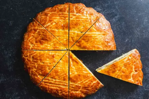 Un délicieux gâteau arménien, doré et coupé en parts, avec une tranche déjà servie.