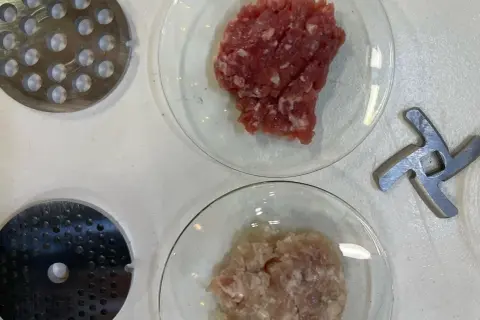 Préparation de viande hachée pour savoir combien de sel et poivre par kg de viande. Disques de hachoir et lames à proximité.