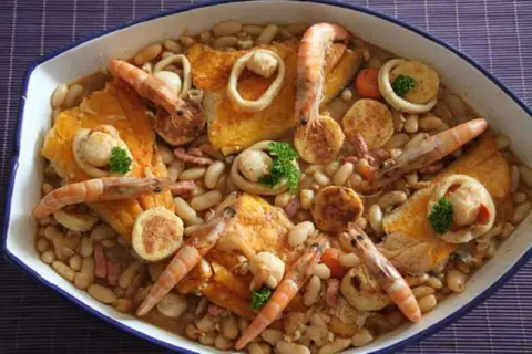 Un cassoulet de la mer facile, un plat généreux avec des crevettes, des calamars et des poissons sur un lit de haricots blancs.