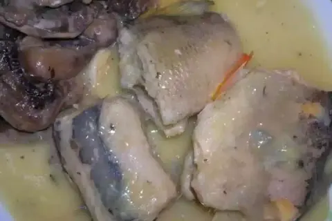 Morceaux de poisson pochés dans une sauce crémeuse, accompagnés de champignons. Une belle présentation pour une pochouse recette.