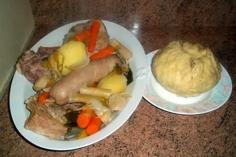 Un plat généreux de la mique origine, avec saucisse, légumes et viande, accompagné d'une mique ronde.