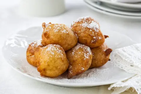 Délicieuses beignets saupoudrés de sucre glace, parfaits pour une recette crotte d'âne maison.