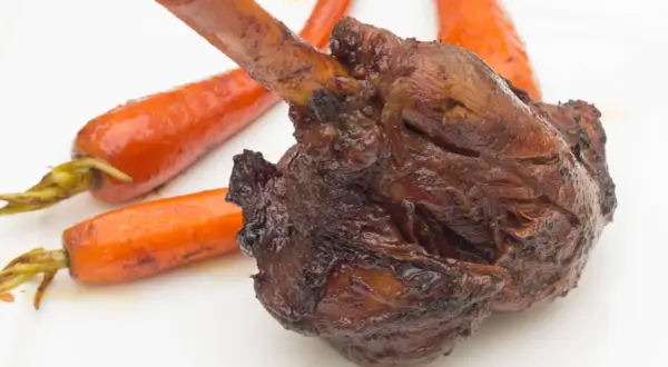 Roussette au vin blanc, une recette de cuisine actuelle, servie avec des carottes glacées sur une assiette blanche.
