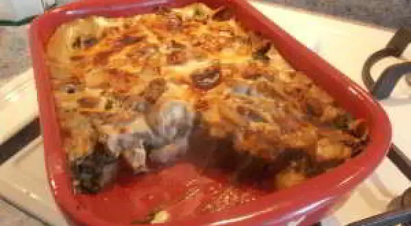 Un gratin des Chartreux tout juste sorti du four, fumant et doré, dans un plat rouge.